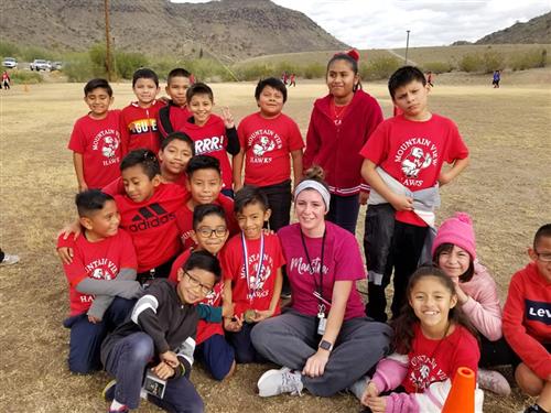 students sit with thier coach outside